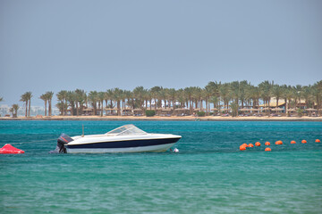 Fototapeta na wymiar Seascape with ripple surface of blue sea water with white speedboat on anchor floating on calm waves