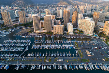 the City of Honolulu Marina, O'ahu, Hawaii.  Tall buildings with marina below full of boats. 