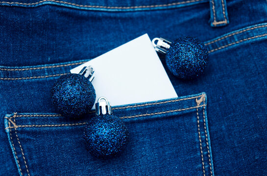 Christmas blue balls with white card copy space over jeans denin pocket like jolly young Christmas graphic background 