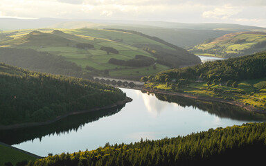 Beautiful reflections on Ladybower Reservoir.  Summers day and golden light during golden hour.  Peak District, England, UK. 