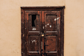Dark wood entrance made of a closed door with broken window and padlock for security