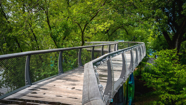 Parkview Tree Canopy Trail curving wood bridge riverfront walkway in Promenade Park over the St. Marys River, Fort Wayne, Allen County, Indiana