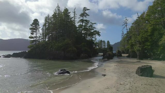 Sandy beach on Pacific Ocean Coast View. Sunny Blue Sky. San Josef Bay, Cape Scott Provincial Park, Northern Vancouver Island, BC, Canada. Canadian Nature Background. Cinematic 4k