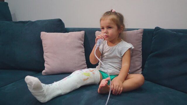 A girl with a broken leg makes an inhalation in the nose for coughing. 