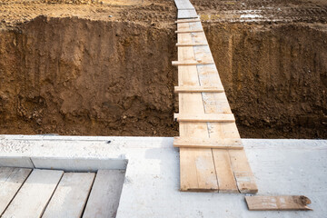 Planken über einem Graben auf einer Baustelle