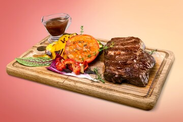 Tasty meat dish with vegetables on wooden board