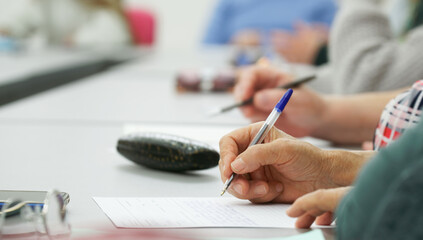 Women complete the forms while seated at a desk in a public building, government social unit, or...