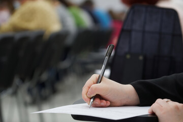 Woman writes down and outlines a lecture with a fountain pen, fills out a form, signs a document,...