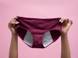 Close-up of woman's hands holding purple panties