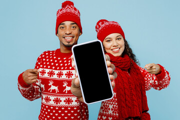 Merry young couple two man woman in red Christmas sweater Santa hat posing hold use show close up...