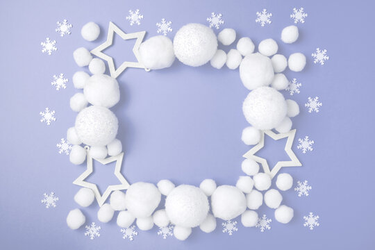 Christmas composition frame. White balls, snowflakes, stars and on purple pastel background