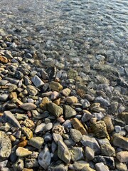 sea pebble coastline, transparent sea water, pebbles bottom
