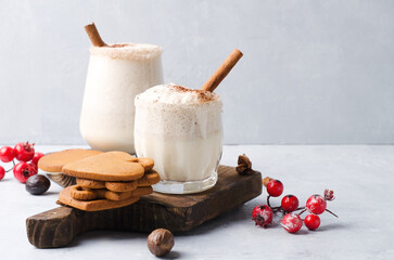Egg nog Christmas drink on a brown background with gingerbread.