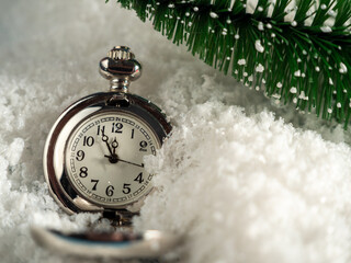 The pocket watch lies on the snow.