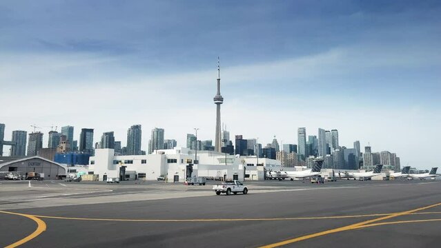 CN tower with modern high rise buildings viewed from airport against blue sky