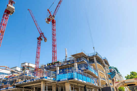 London, UK - June 22, 2018: Apartment flat or office buildings modern skyscrapers under construction with cranes sign for Morrisroe scaffold on sunny summer day low angle view