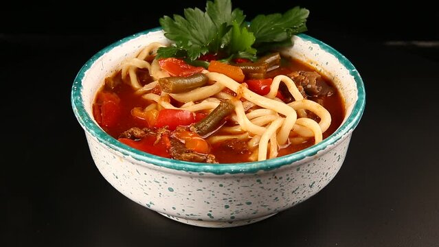 Traditional dish with noodles. Lagman. On a dark background. Selective focus.