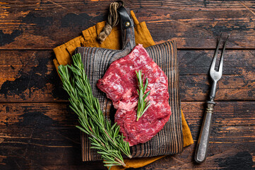 Raw alternative skirt beef steak on butcher board.  Wooden background. Top view