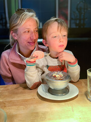 Mother with son eating dessert in restaurant