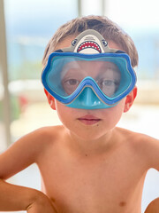 Shirtless boy wearing swimming goggles