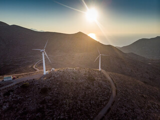 Wind turbines on mountain range during sunset