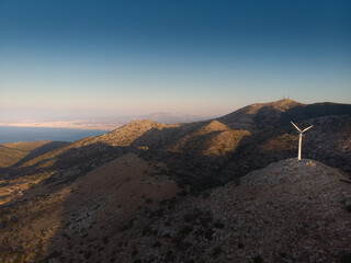 Wind turbine on mountain against sky