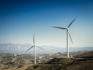 Wind turbines on mountain against clear sky