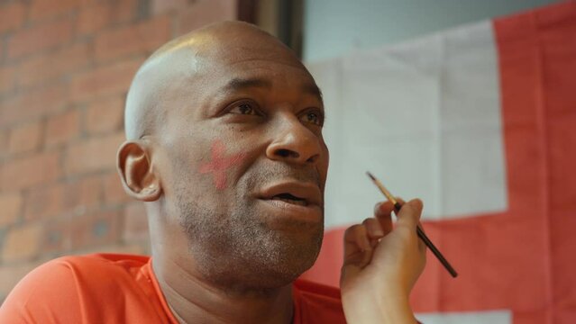Close-up of woman applying face paint on soccer fans face