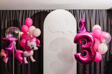 Birthday party decorated with pink, violet balloons in the style unicorn, rainbow, my little pony. Idea for decorating party. Reception. Copy space. Birthday arch for 3 years and a photo wall. - obrazy, fototapety, plakaty