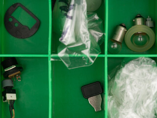 The parts are in the box of a person engaged in repairing electronics. View from above. Closeup