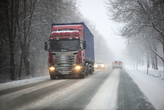 Blurred background of a moving truck on a highway in winter. Freight transport, transportation of goods.