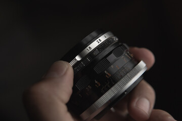 diafragma abierto f1.8 mano sujetando un objetivo fotográfico manual vintage