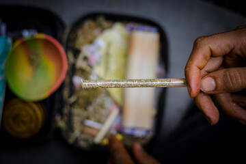 Sao Paulo, SP, Brazil - November 5 2021: Brown hands holding a cannabis cigarette with cellulose...