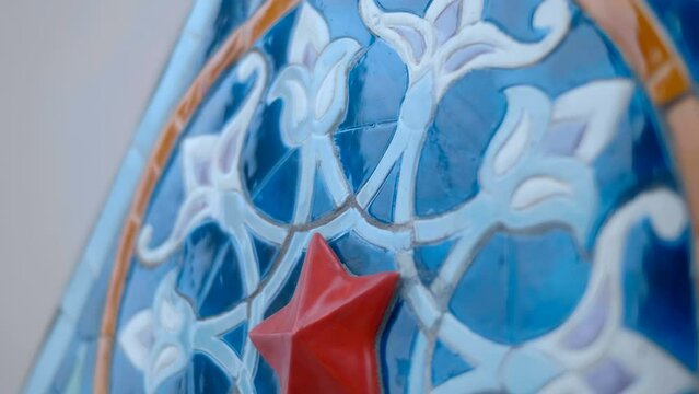 Beautiful colorful ceramic tiles with oriental type floral pattern glisten with voluminous textures and reflect the surroundings. Closeup. Shot in motion