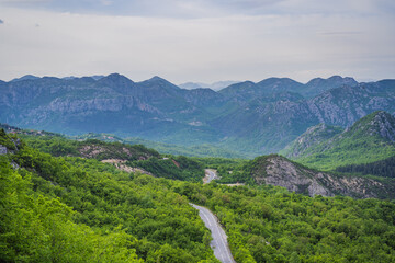 Fototapeta na wymiar Montenegro. Picturesque canyon. Mountains surrounding the canyon. Forests on the slopes of the mountains. Haze over the mountains