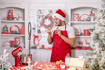 hombre alegre caucásico, haciendo y decorando galletas navideñas para celebrar la navidad en...