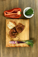 Cow bowels presented on a wooden board with ingredients, ready to grill