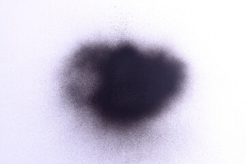 a black spray paint stain on a white paper background