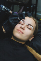 Fototapeta na wymiar Young woman during professional eyebrow mapping procedure before permanent makeup