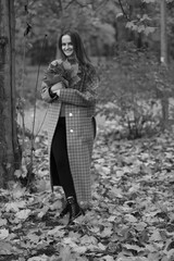 Naklejka premium Young woman collecting autumn leaves in black and white