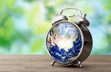 Fototapeta na wymiar Earth day. Planet globe in alarm clock.