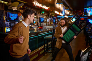 Two man hooligan football team fans get in bar fight