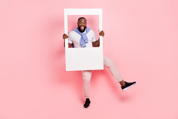 Photo of young energetic positive man have fun during photo shoot isolated on pink pastel color...