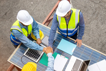 A group of teamwork joins hands together with solar photovoltaic panels at the workplace in the...