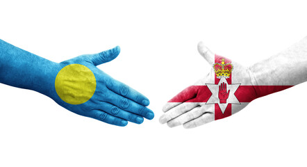 Handshake between Northern Ireland and Palau flags painted on hands, isolated transparent image.