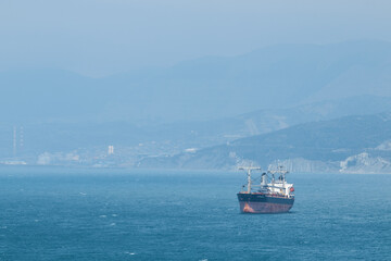 sea tanker, barge, ship in sea in distance, calm water, sunshine and sun, calm, seascape, in...