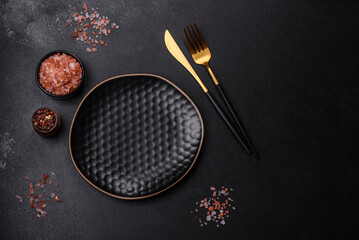 Empty black plate over dark stone background with free space