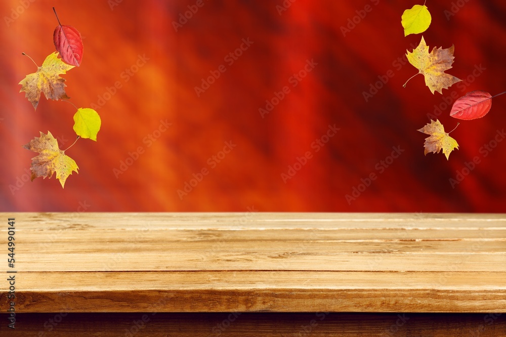 Poster Blank wooden table top with fall leaves.