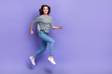 Fototapeta na wymiar Full length photo of cheerful pretty girl running empty space black friday sale low price clothes isolated on purple color background