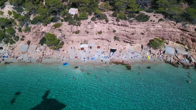busy dream beach for tourists and locals in ibiza. Tranquil aerial view flight